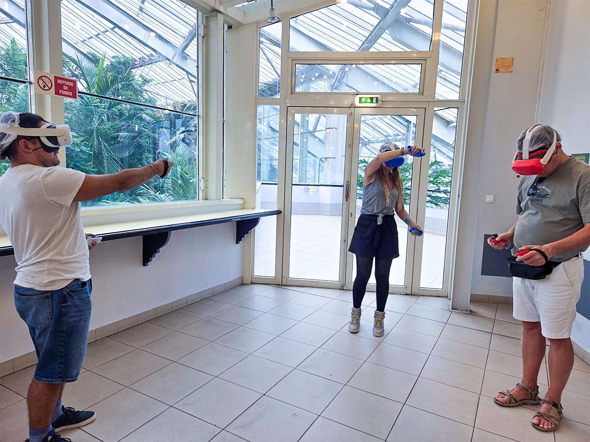 Trois participants en immersion dans une expérience de réalité virtuelle lors de la Journée des Aidants à Nice, chacun équipé d'un casque VR et de manettes dans une salle de formation lumineuse.